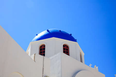 Santorini, Greece - White church with blue dome on blue sky backgroundの写真素材