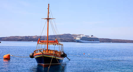 Santorini island, Greece - Boat and cruise ship on Nea Kameni island backgroundの写真素材
