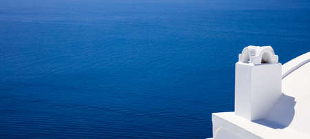Santorini island, Greece - White chimney on blue sea backgroundの写真素材
