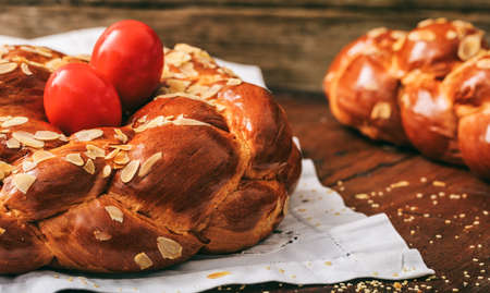 Easter traditional bread and red eggs on a tableの写真素材