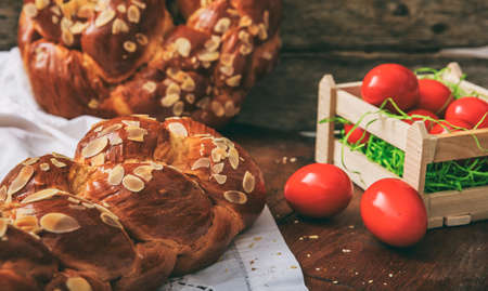 Easter traditional bread and red eggs on a tableの写真素材