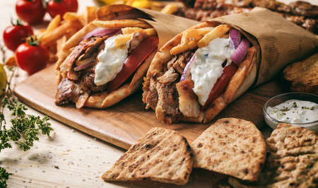 Greek gyros wrapped in pita breads on a wooden backgroundの写真素材