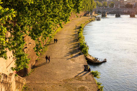 Couples walking by the Tiber river in Rome, Italyの写真素材