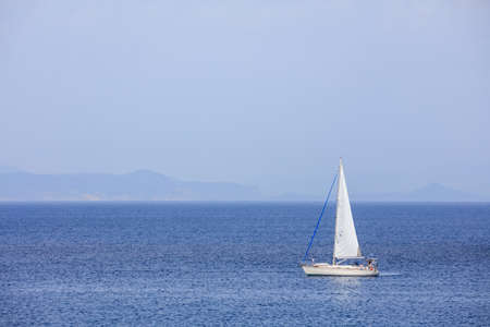 Sailing boat on a blue sea and sky backgroundの写真素材