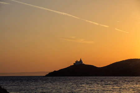 Greece, Kea island. Lighthouse on a cape at sunsetの写真素材