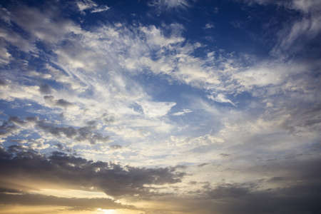 Few clouds on a blue sky background at sunsetの写真素材