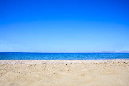 Sandy beach on blue sky and sea backgroundの写真素材