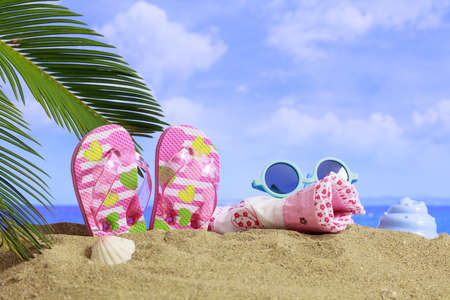 Summer vacations - kid's flip flops on a sandy beachの写真素材