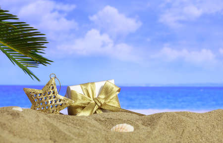 Christmas star and gift on a sandy beach - copy spaceの写真素材