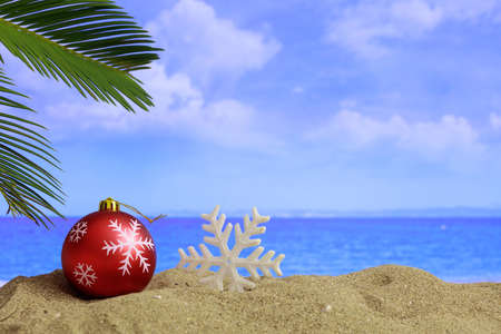 Christmas ball and ornament on a sandy beach - copy spaceの写真素材