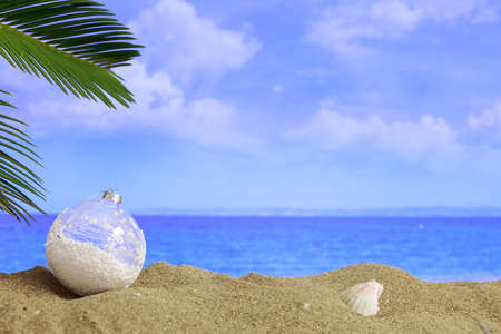 Christmas ball on a sandy beach - copy space