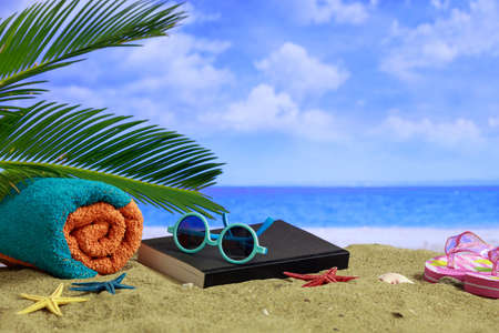 Summer vacations concept - Sunglasses and towel on a sandy beachの写真素材