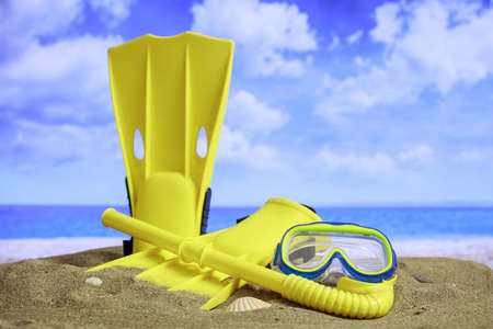 Summer vacations concept - Flippers and mask on a sandy beach