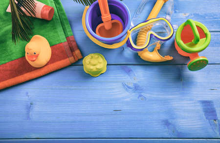 Summer beach toys on blue wooden background with copy space - top viewの写真素材