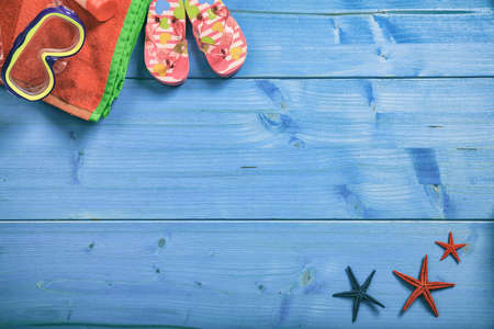 Summer beach accessories on blue wooden background with copy space - top viewの写真素材
