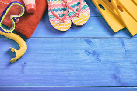 Summer beach accessories on blue wooden background with copy space - top view