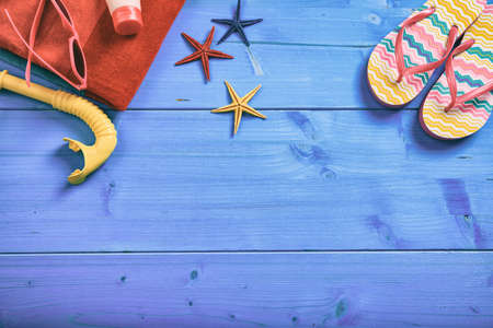 Summer beach accessories on blue wooden background with copy space - top viewの写真素材