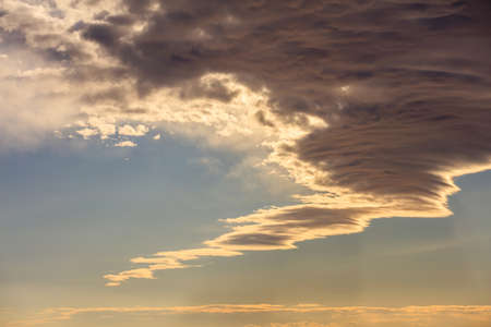 A few clouds on a blue sky background at sunsetの写真素材