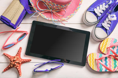 Summer vacation accessories and tablet on white wooden background - top viewの写真素材