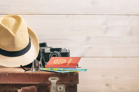 Travel accessories on an old suitcase - white wooden background - copy spaceの写真素材