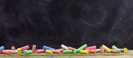 School concept - Colorful chalks and a blackboardの写真素材