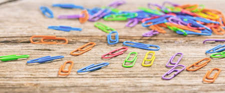 Colorful paper clips close up on wooden backgroundの写真素材