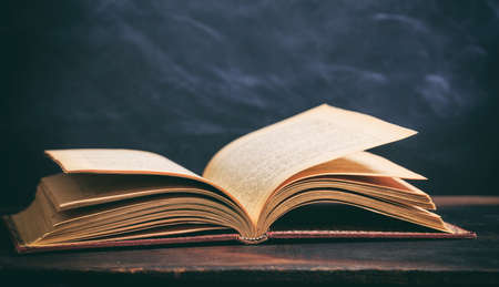 Education concept. Old book on blackboard backgroundの写真素材