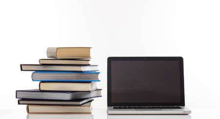 Education concept. Books stack and a laptop isolated on white background - copy space