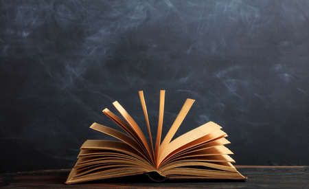 Education concept. Old book on blackboard backgroundの写真素材