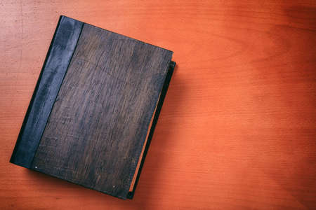 Old book on wooden background - copy spaceの写真素材