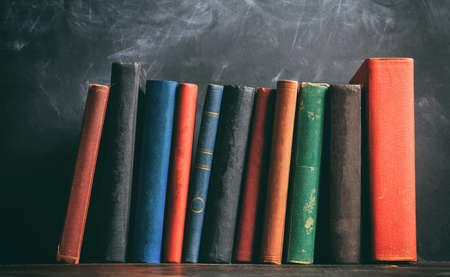 Education concept. Old books on blackboard backgroundの写真素材