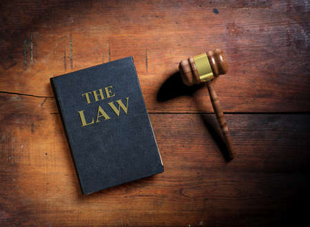 Law book and judge gavel on wooden background. 3d illustration