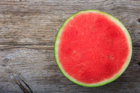 Half seedless watermelon on a wooden table - top viewの写真素材