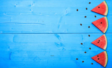 Watermelon pieces on a blue board- top viewの写真素材