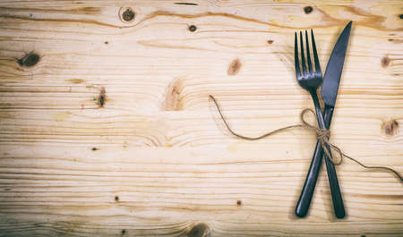 Table setting with fork and knife on wooden backgroundの写真素材