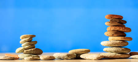 Zen stones stacked on blue sky and sea backgroundの写真素材