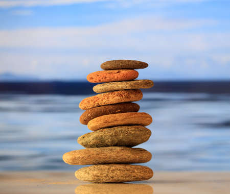 Zen stones stacked on blue sky and sea backgroundの写真素材