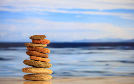 Zen stones stacked on blue sky and sea background