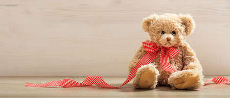 Teddy bear sitting on a wooden backgroundの写真素材