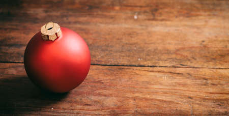 Red christmas ball on wooden background, copy spaceの写真素材
