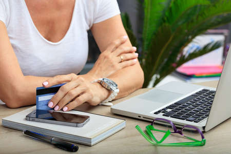 Online shopping concept. Woman holding a credit card in an office backgroundの写真素材