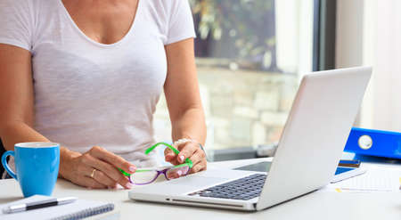 Woman working with a laptop in an office backgroundの写真素材
