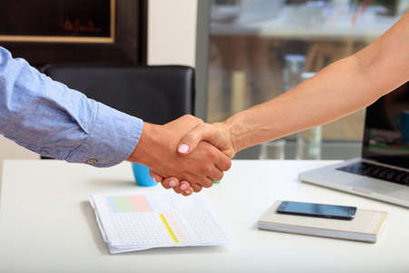 Business handshake in an office backgroundの写真素材