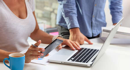 Woman holding a smartphone in an office backgroundの写真素材