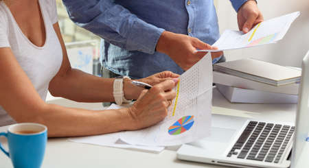 Man and woman working with an analysis report in an office backgroundの写真素材