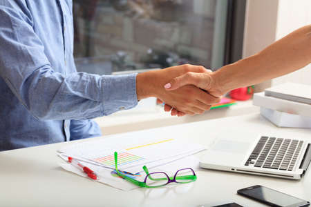 Business handshake in an office backgroundの写真素材