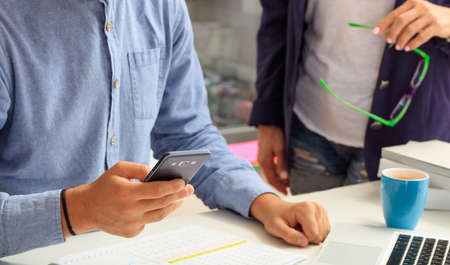 Man holding a smartphone in an office backgroundの写真素材