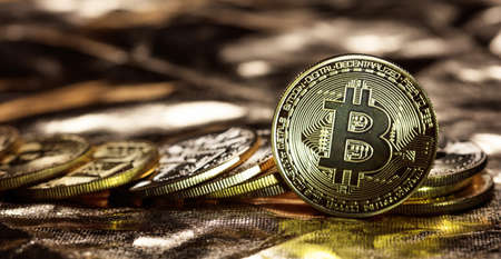 Golden shining bitcoins stacked on golden background