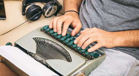 Man typing on a vintage typewriter. Close up on handsの写真素材