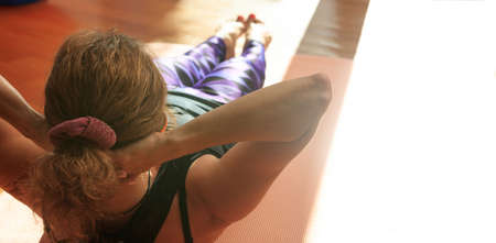Woman in a pilates class, exercising on wooden floorの写真素材